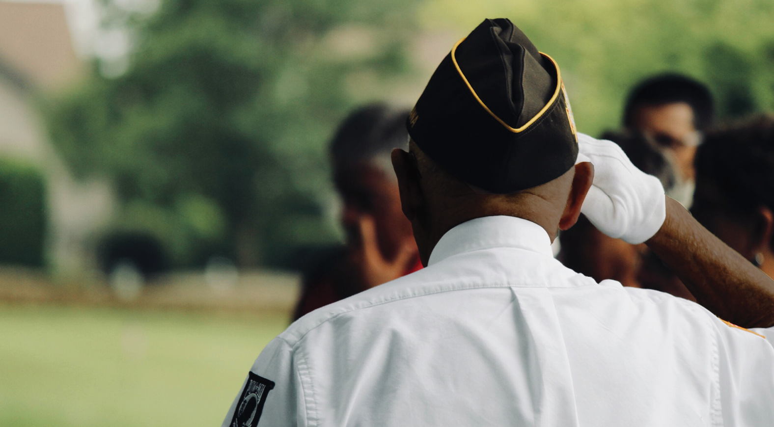back view of an African American wearing military uniform with hand in salute
